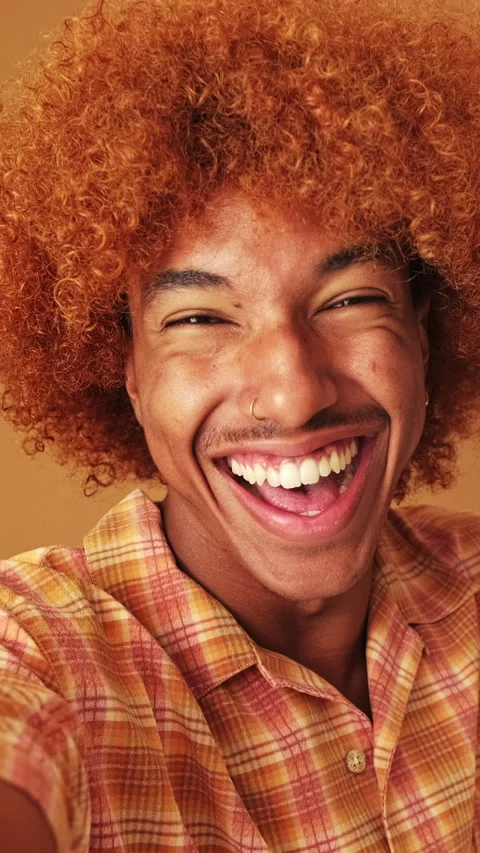 Guy looking at the camera taking selfie, victory sign, isolated on brown Stock Footage 255963911