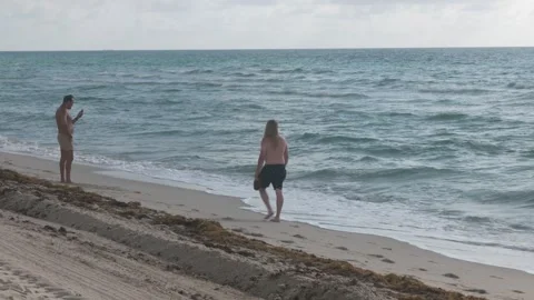 Guy Looking At Cellphone On The Beach Stock Footage 311548171