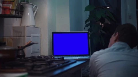 Guy looking at chroma key notebook computer display at kitchen near stove Video stock 83253296