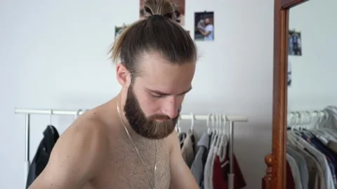 Guy is looking into the mirror Putting together an outfit choosing shirt Stock Footage 147896186