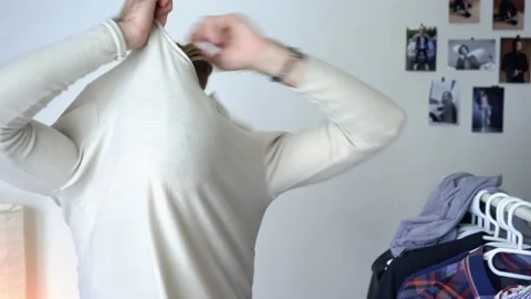Guy is looking into the mirror /  Putting together outfit taking off the shirt Stock Footage 147898109