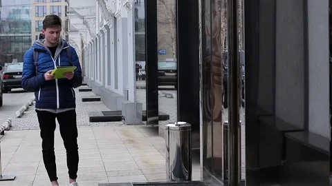 The guy is looking for a store on the city map. He uses a tablet PC Stock Footage 73462470