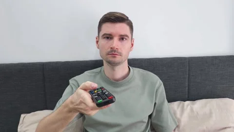 Guy looking television show at comfortable couch alone. Man choosing channel Stock Footage 284044346