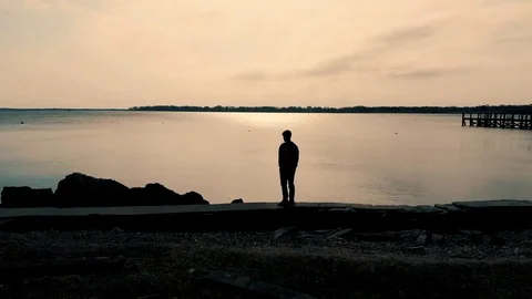 Guy Looking At Water Drone Shot Stock Footage 91301729