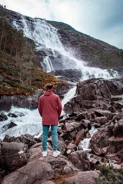 A guy is looking at a waterfall 스톡 사진