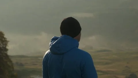 A guy looks around in the mountains, a man looks at a beautiful view Stock Footage 171636687