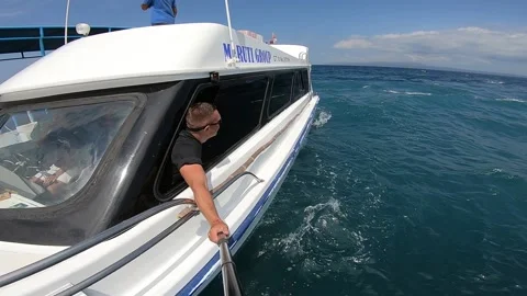 The guy looks back from the side of the speed boat Video stock 162675850