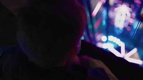 The guy looks down through the glass toward the bright neon lights Stock Footage 154123992