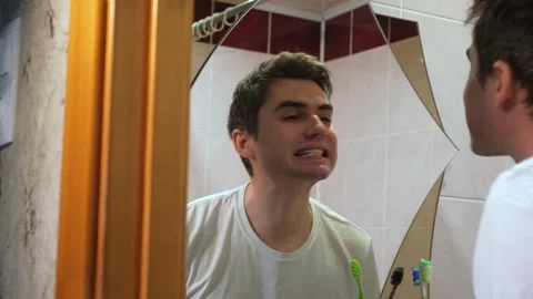 A guy looks at his teeth after brushing his teeth, a man looks after his teeth Stock Footage 264887399