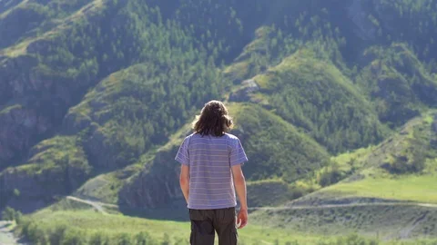 The guy looks at the mountains the height Stock Footage 115638632