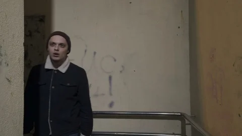 Guy looks out from around the corner and says something Stock Footage