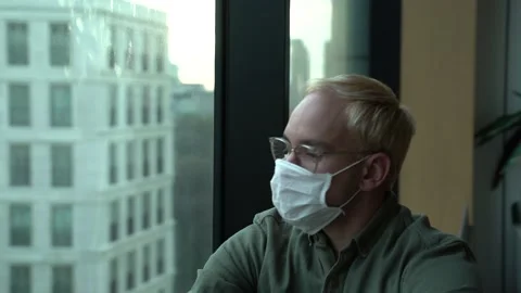 The guy looks out the window from the office Stock Footage 130500069