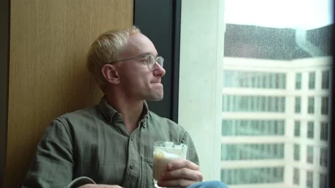 The guy looks out the window from the office Stock Footage 130500087