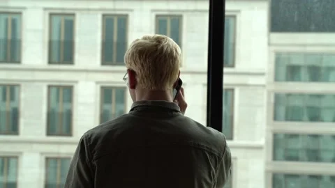 The guy looks out the window from the office Stock Footage 130500115