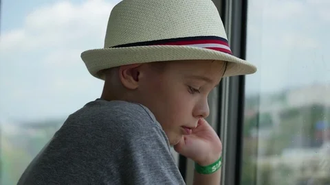 The guy looks out the window at the sun. Plays a hand with sunlight Vidéo 74357516