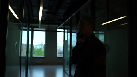 The guy looks at the phone in the office Stock Footage 130877720