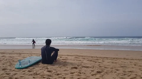 The guy looks like riding on the waves surfers 動画素材 103204511