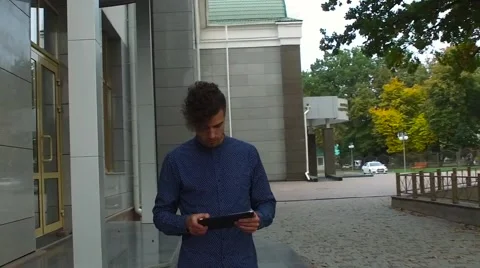 The guy looks at the tablet in the street Stock Footage 68593399