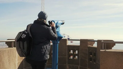 The guy looks through the viewing binoculars from a height of the city Barcelona Stock Footage 101269785