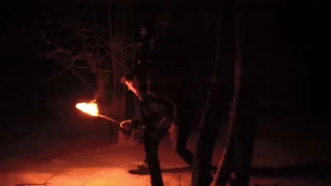 Guy lost in a night forest at winter run's around with a torch scared about Stock Footage 154699163