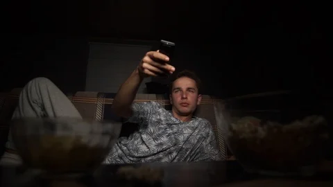 The guy is lying on the bed and watching TV Stock Footage 126093402