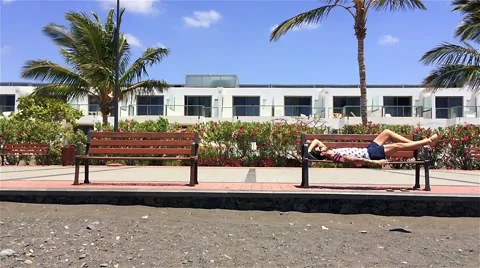 Guy lying bench beach Stock Footage 50593150