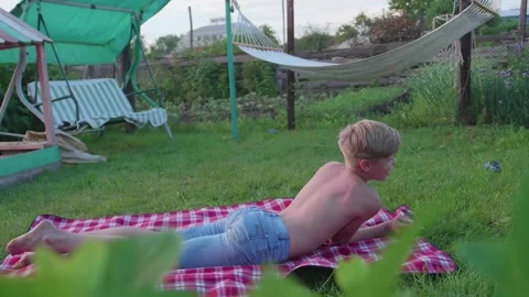 The guy is lying on the lawn on a hot summer day. The child is fun and active to Video stock 91900048