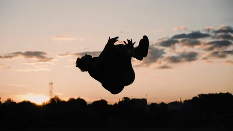 The guy makes a leap back with a coup in the evening against the sunset Stock Footage 203916968