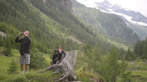 The guy makes the photo on the background of snow-capped peaks of the Alps Stock Footage 51913498