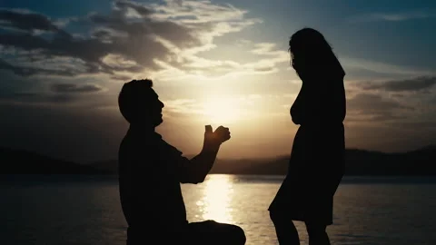 The guy makes a proposal to the girl to get married by the sea at sunset. Vídeos de archivo 196985761