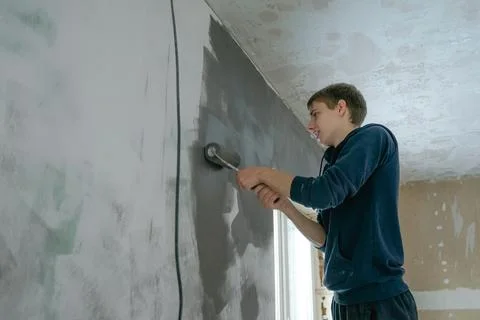 Guy makes repairs in the house Stock Photos
