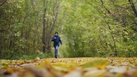 The guy makes a run at autumn Park, yellow leaves lay underfoot. Sports outdoors 库存影片 80342213