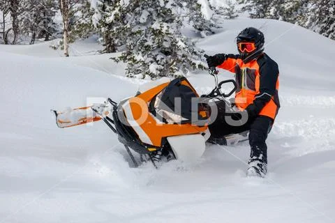 The guy makes a turn on a snowmobile, leaning on his left leg Stock Photos