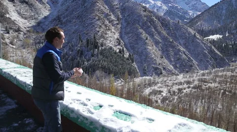Guy is making snowballs and having fun in winter beautifull mountains landscape Video stock 67963858