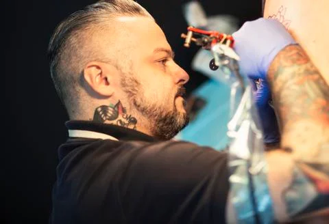 Guy is making tattoo, in a studio. Stock Photos