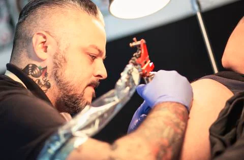 Guy is making tattoo, in a studio. Stock Photos