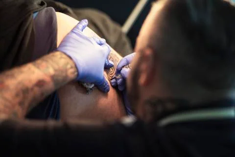 Guy is making tattoo, in a studio. Stock Photos