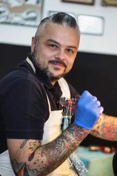 Guy is making tattoo, in a studio. Stock Photos