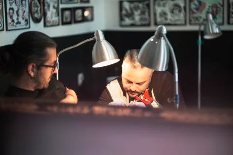 Guy is making tattoo, in a studio. Stock Photos
