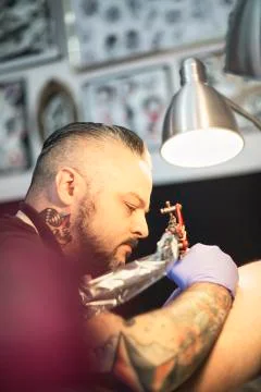 Guy is making tattoo, in a studio. Stock Photos