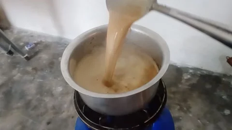 A guy making tea called chai in a room on a cylinder. 動画素材 144600050