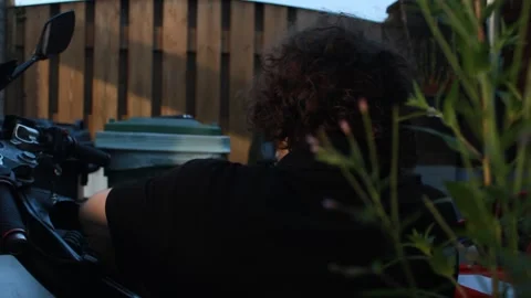 Guy, man, boy, mechanic working on a motorcycle, bike dark cinematic style Stock Footage 282511734