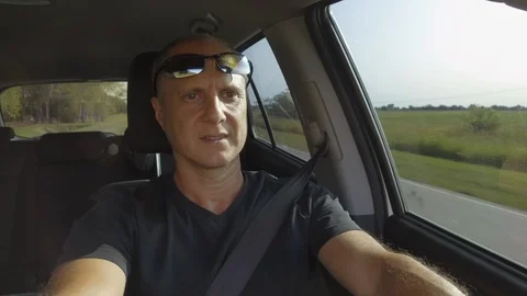 Guy Man Driving a car SUV on a Country side Road, green rural valley. Sunny day Stock Footage 123237420