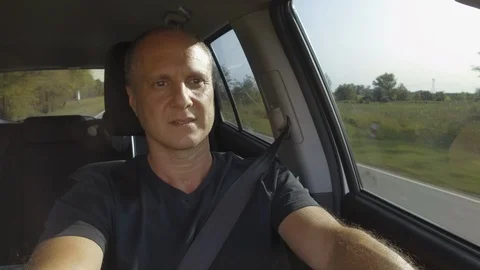 Guy Man Driving a car SUV on a Country side Road, green rural valley. Sunny day Stock Footage 123255197