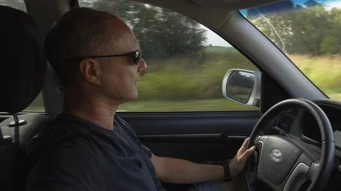 Guy Man Driving a car SUV on a Country side Road, green rural valley. Sunny day Stock Footage 123255455