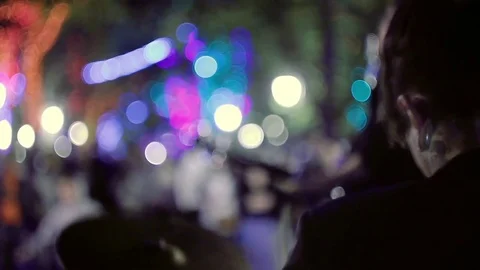 The guy man plays drums in the city's night park, against the backdrop of Video stock 73488950