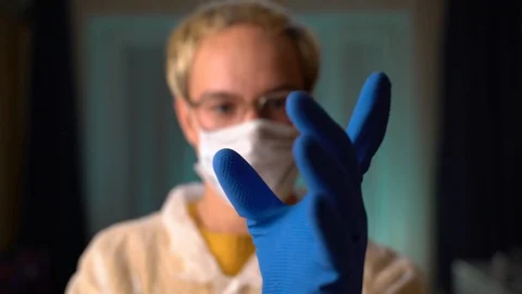 The guy in the mask puts on gloves Stock Footage 128691961