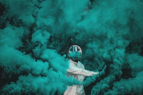 Guy in mask standing in between blue smoke bombs Stock Photos