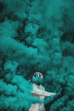 Guy in mask standing in between blue smoke bombs. vertical Stock Photos