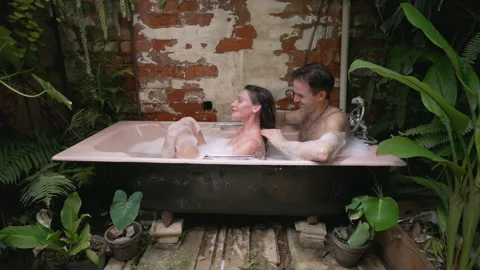 A guy masssages a woman's neck while in an outdoor foam bath. Stock Footage 170445117